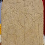 Ancient Egyptian limestone stela showing Ramses I before the god Seth.
