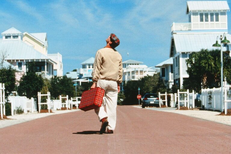 Jim Carrey as Truman Burbank walking through the planned town of Seahaven in The Truman Show; editorial film still used for commentary.