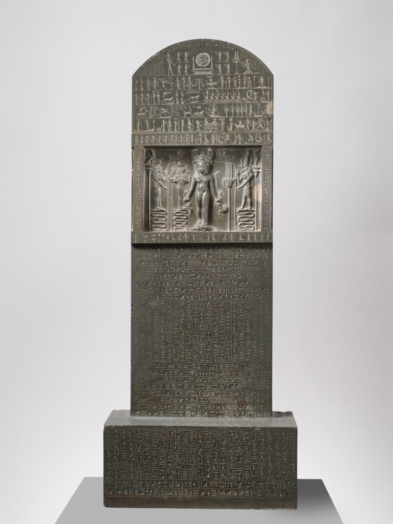 Horus the Child standing on crocodiles on the Metternich Stela, flanked by Egyptian deities